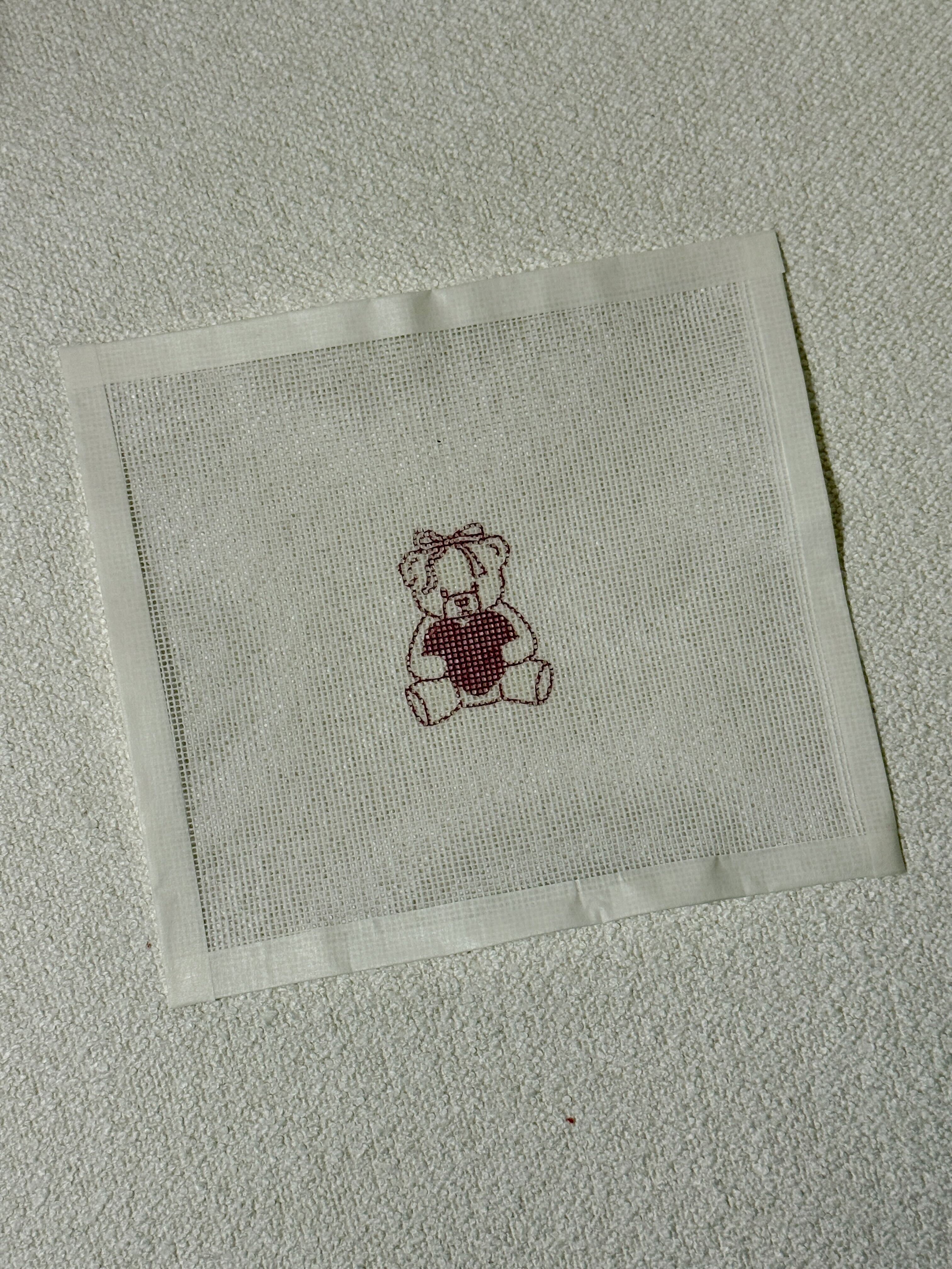 Needlepoint Design with Bear holding heart on a white background