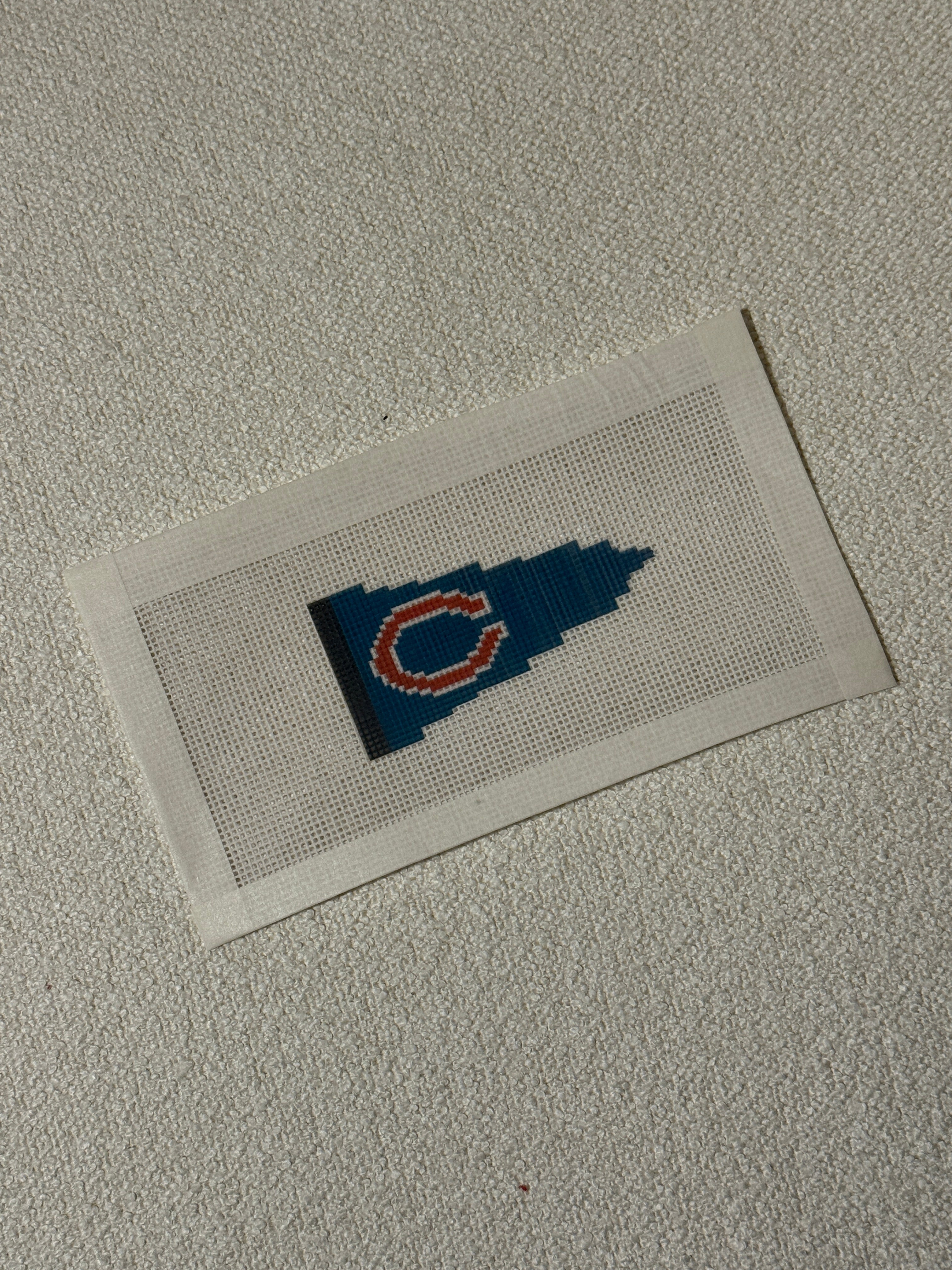 Small cross stitch patch of an football team outline on a flag