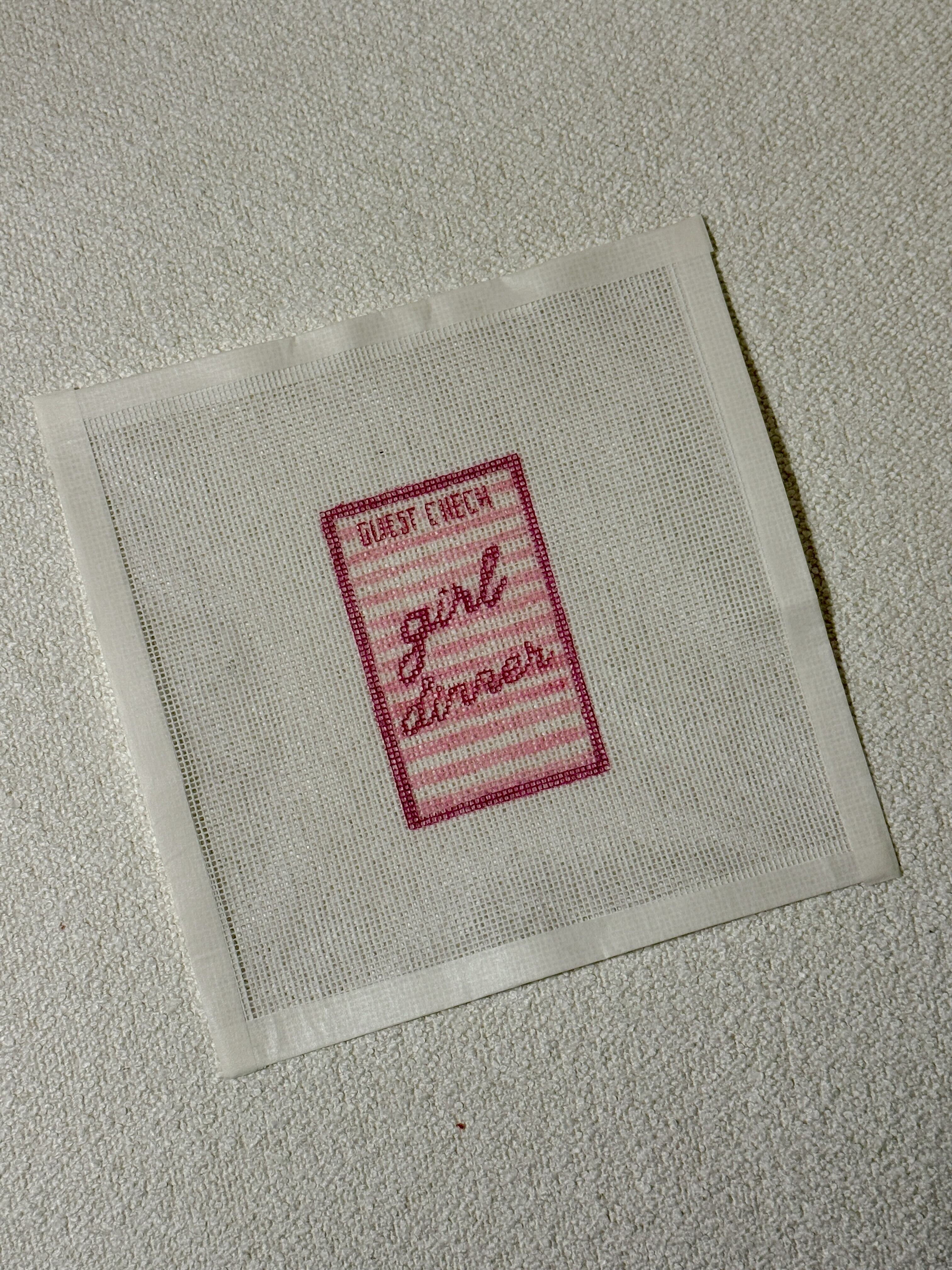 Needlepoint Design with 'Girl Dinner' text on a white background