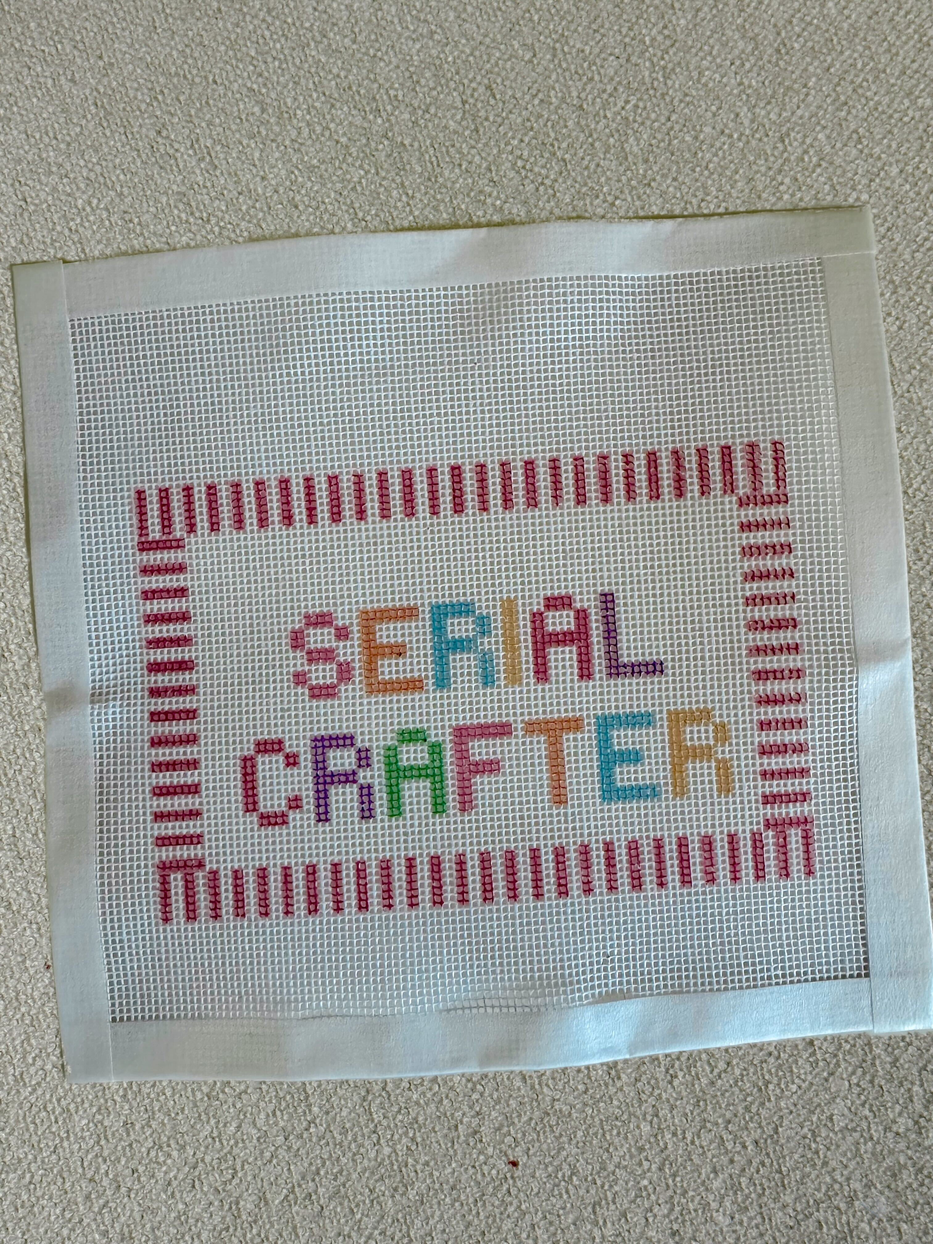 Needlepoint Design with Serial Crafter saying and a striped pink boarder on a white background
